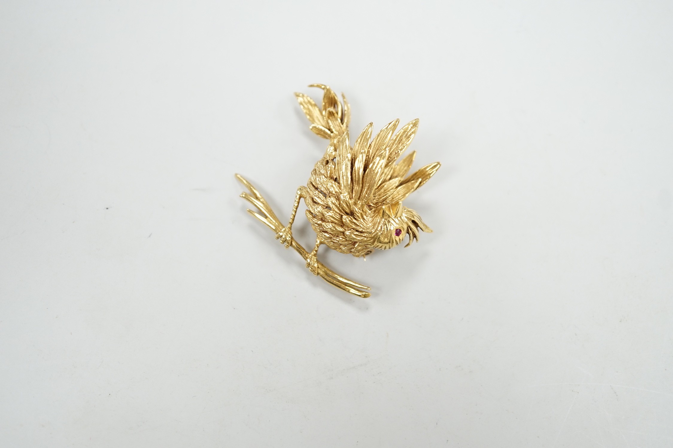 A 1960's Boucheron of Paris 18ct gold and ruby set brooch, modelled as a bird upon a branch, signed, width 43mm, gross weight 20 grams, with Boucheron box.